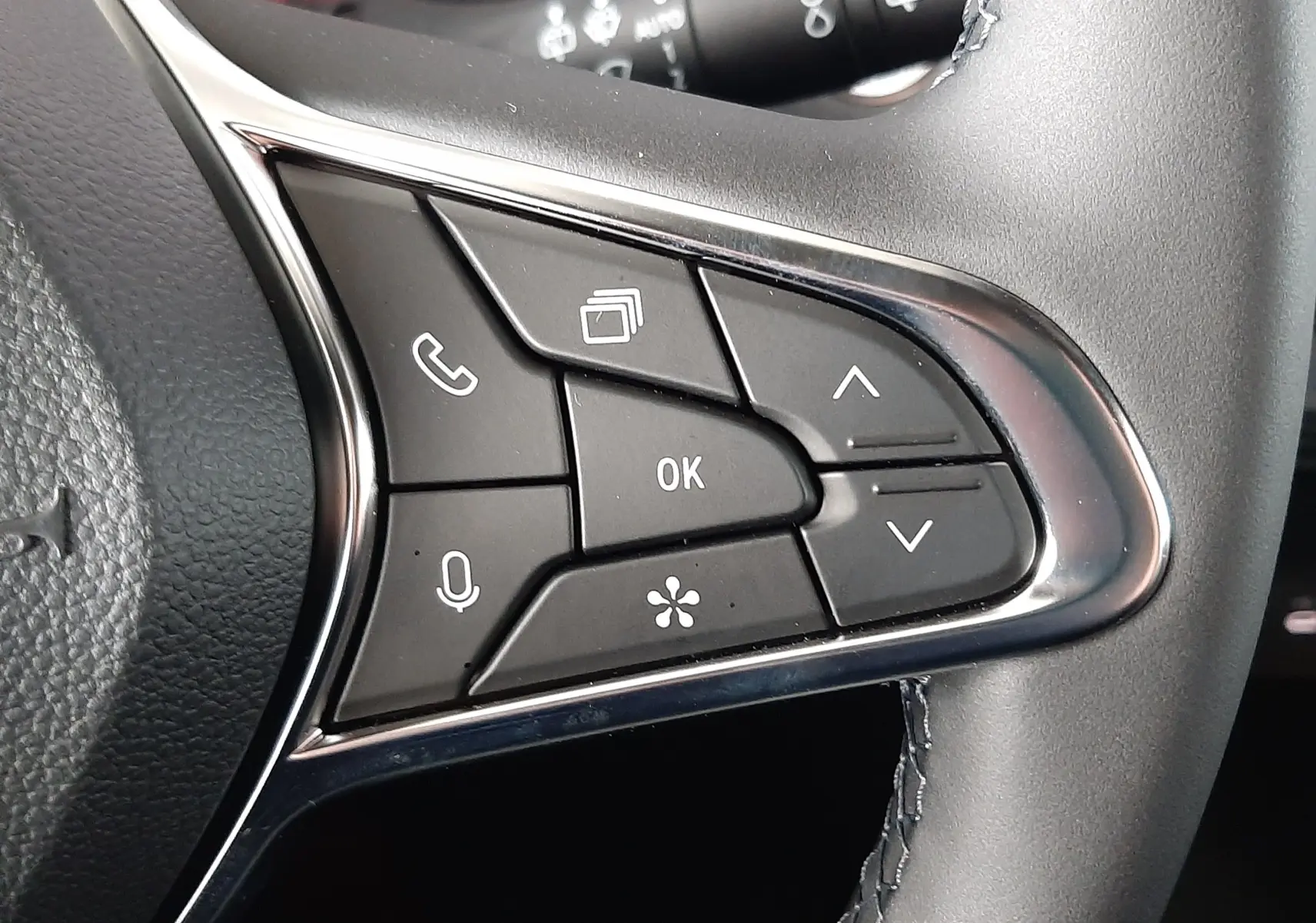 Gros plan sur les commandes multifonctions à droite du volant du Renault Captur E-Tech Hybrid 2024, finition noire.