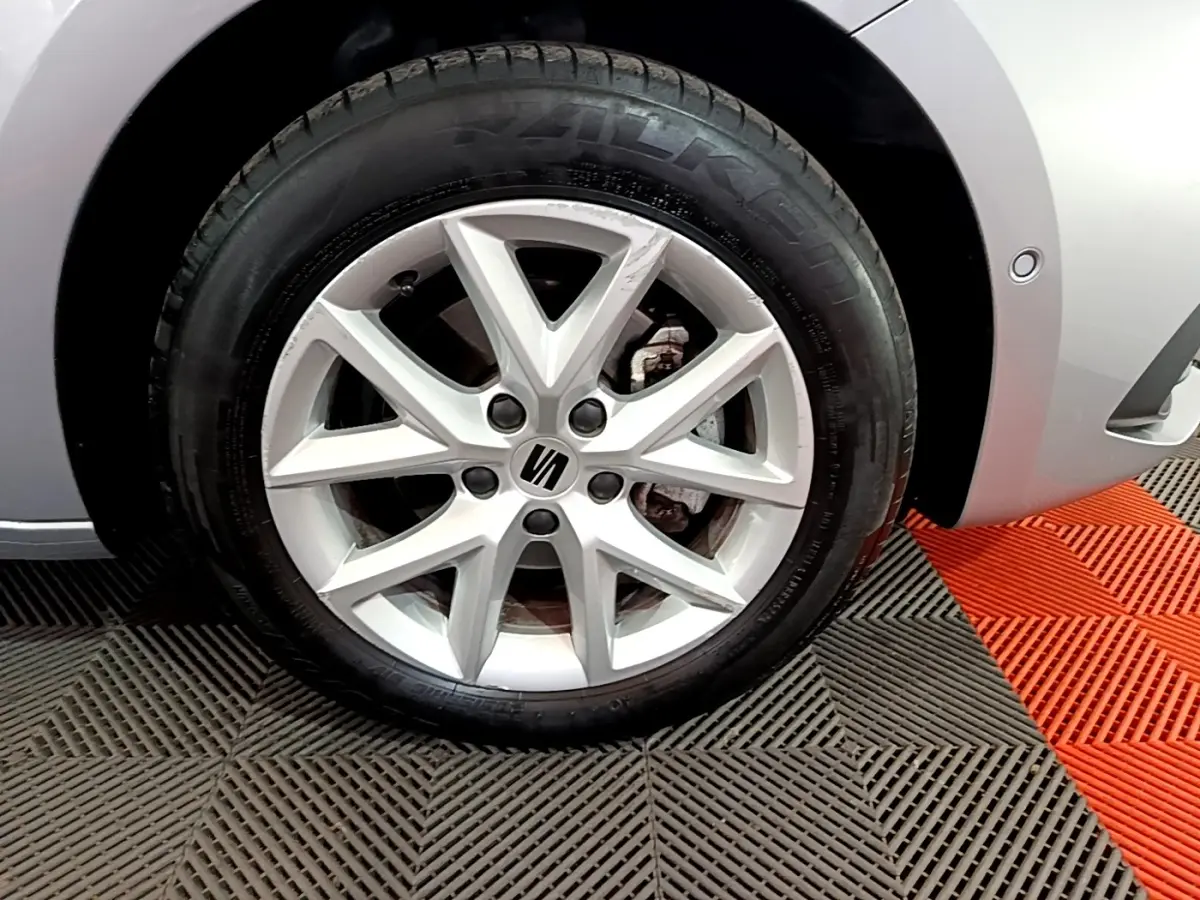 Gros plan sur la roue avant droite gris foncé d'une SEAT LEON 1.0 TSI 110 S&S Business avec jante alliage à 5 branches doubles.