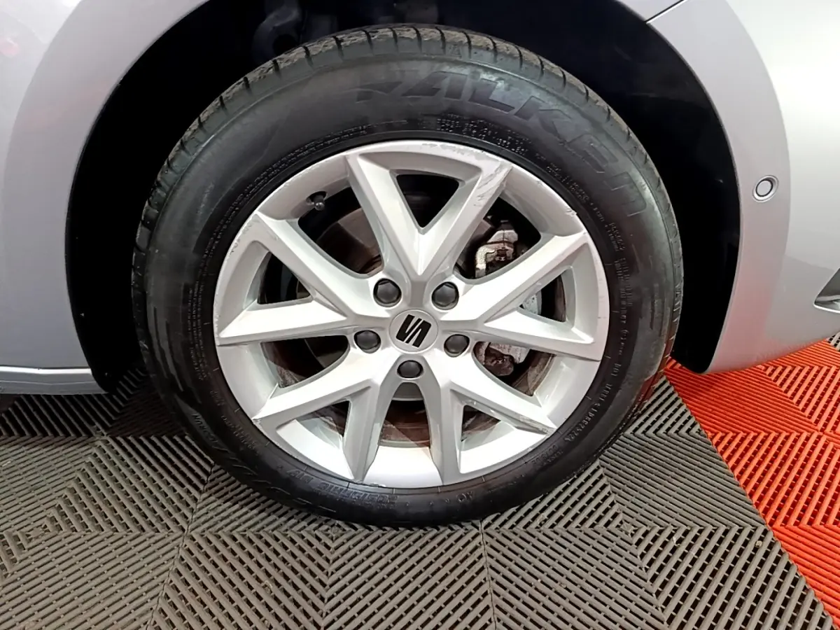 Gros plan sur la roue avant droite gris foncé d'une SEAT LEON 2023 avec jante alliage à 5 branches doubles.