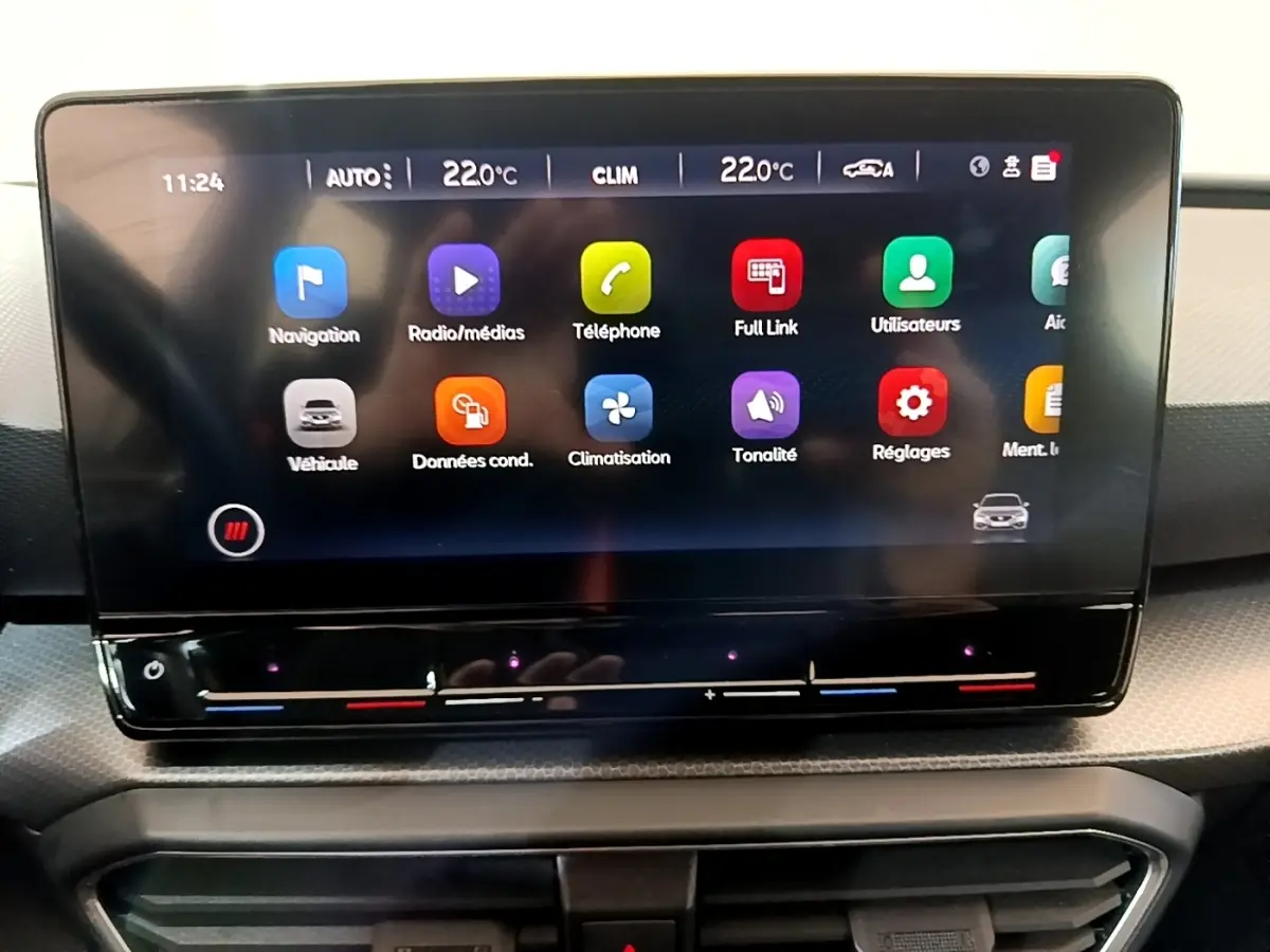 Écran tactile central du tableau de bord de la SEAT LEON gris foncé, affichant les menus multimédias et climatisation.