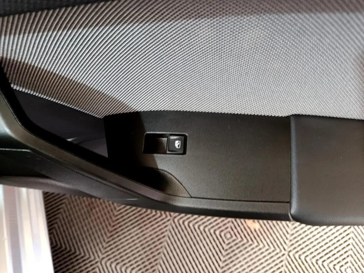 Gros plan sur le panneau de commande de la portière côté gauche d'une SEAT LEON gris foncé 2023.