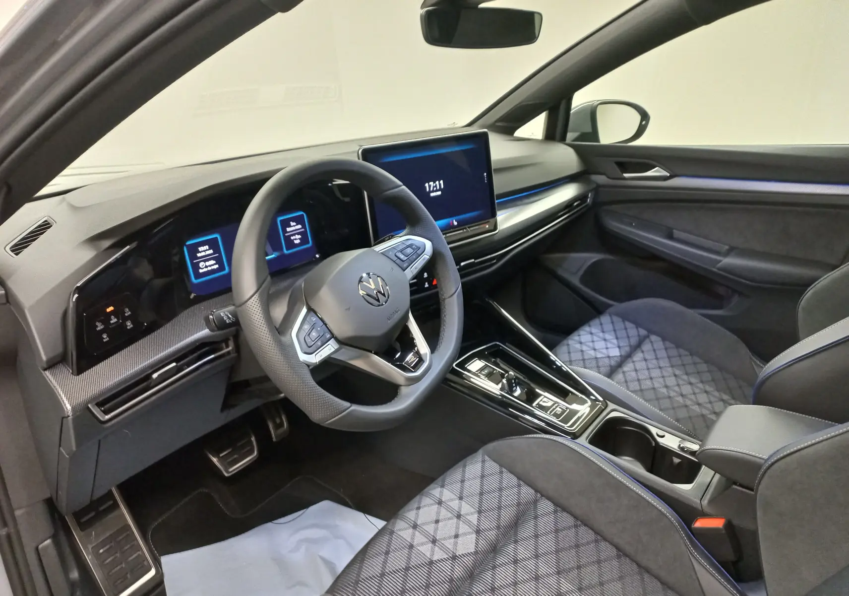 Vue intérieure côté conducteur de la Volkswagen Golf 2.0 TDI R-Line avec tableau de bord numérique et sellerie tissu gris.