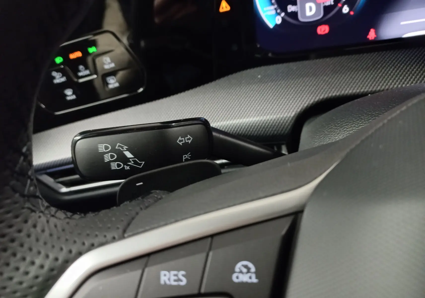 Gros plan sur le volant et commandes du tableau de bord d'une Volkswagen Golf 2.0 TDI 150 DSG7 R-Line, intérieur noir.