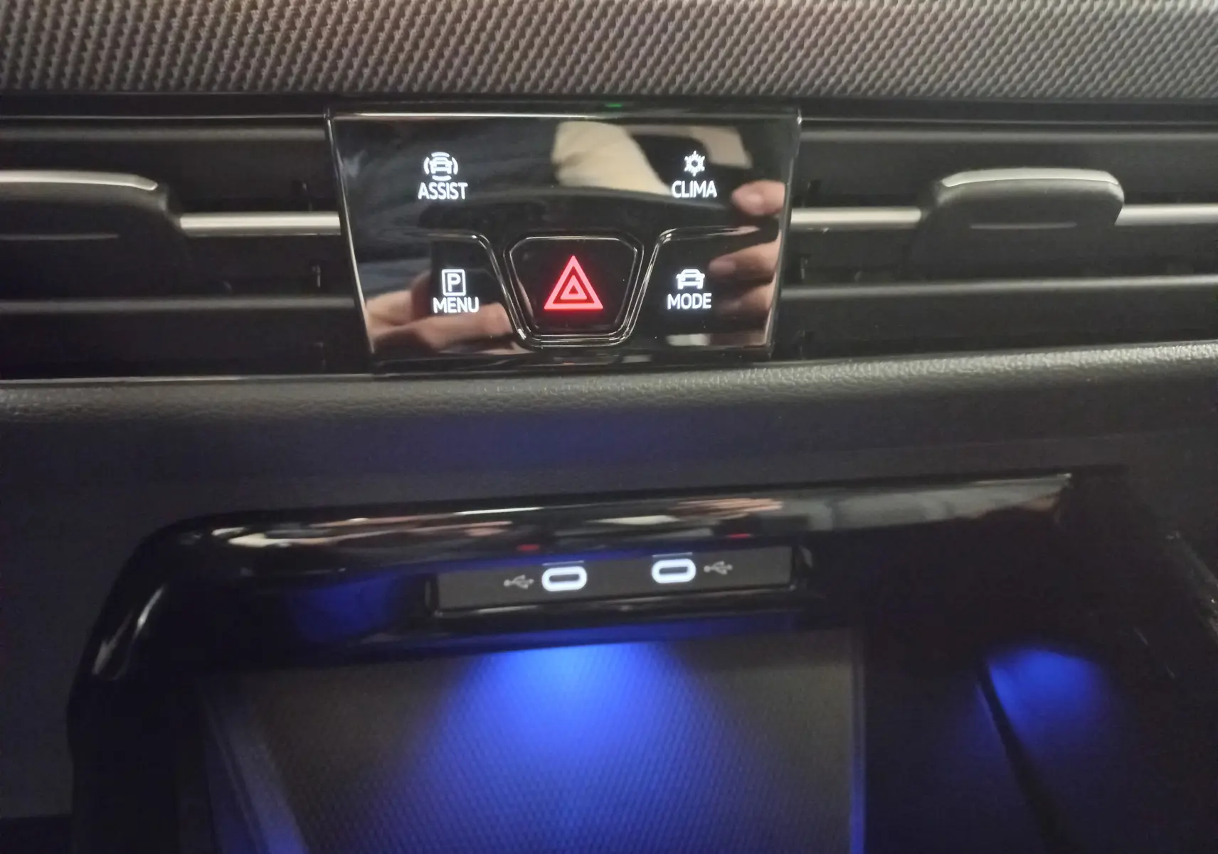 Détail du tableau de bord de la Volkswagen Golf 2.0 TDI 150 DSG7 R-Line avec boutons de commande et éclairage bleu.