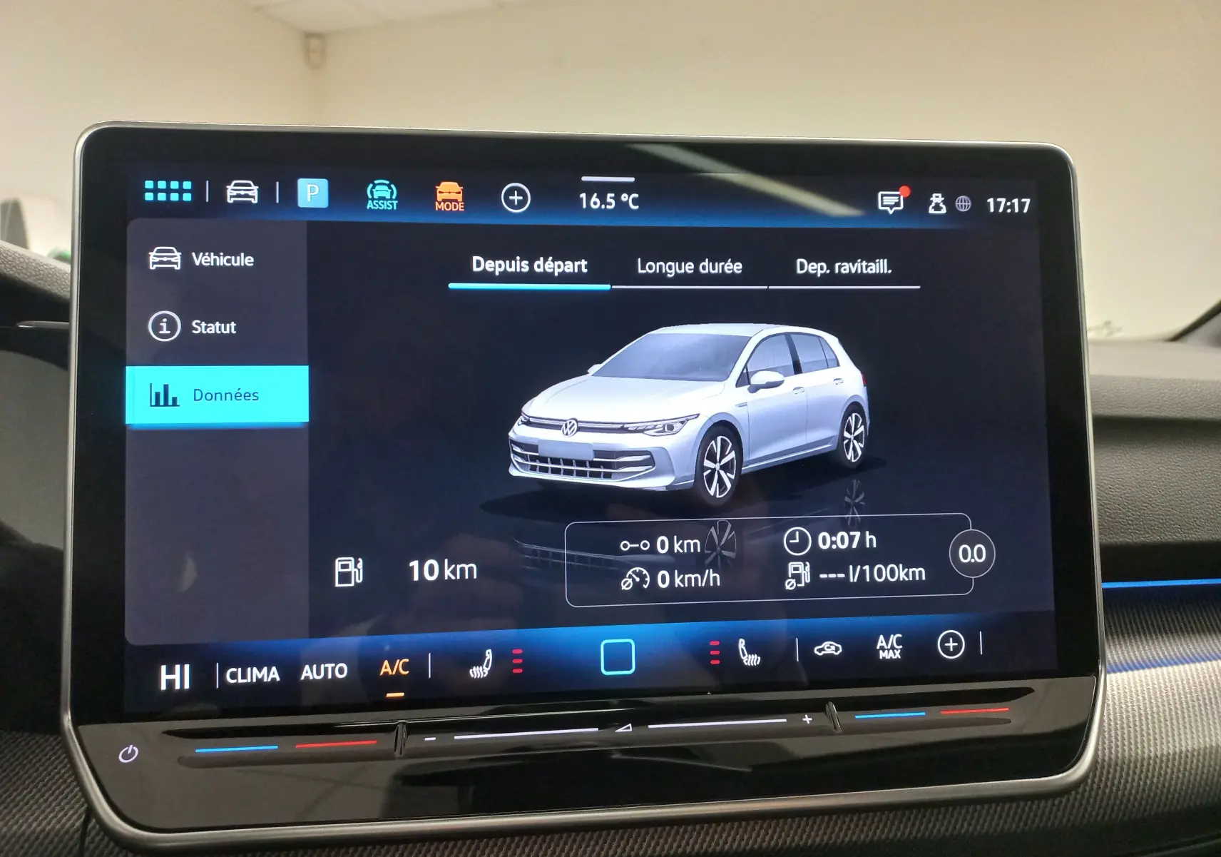 Écran tactile affichant une vue 3/4 avant d'une Volkswagen Golf gris lunaire dans l'interface du véhicule.