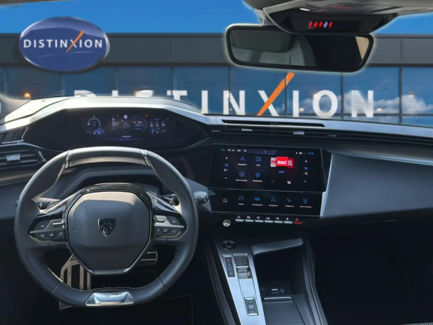Vue intérieure avant de la Peugeot 308 gris 2025, avec tableau de bord numérique et écran tactile central allumé.