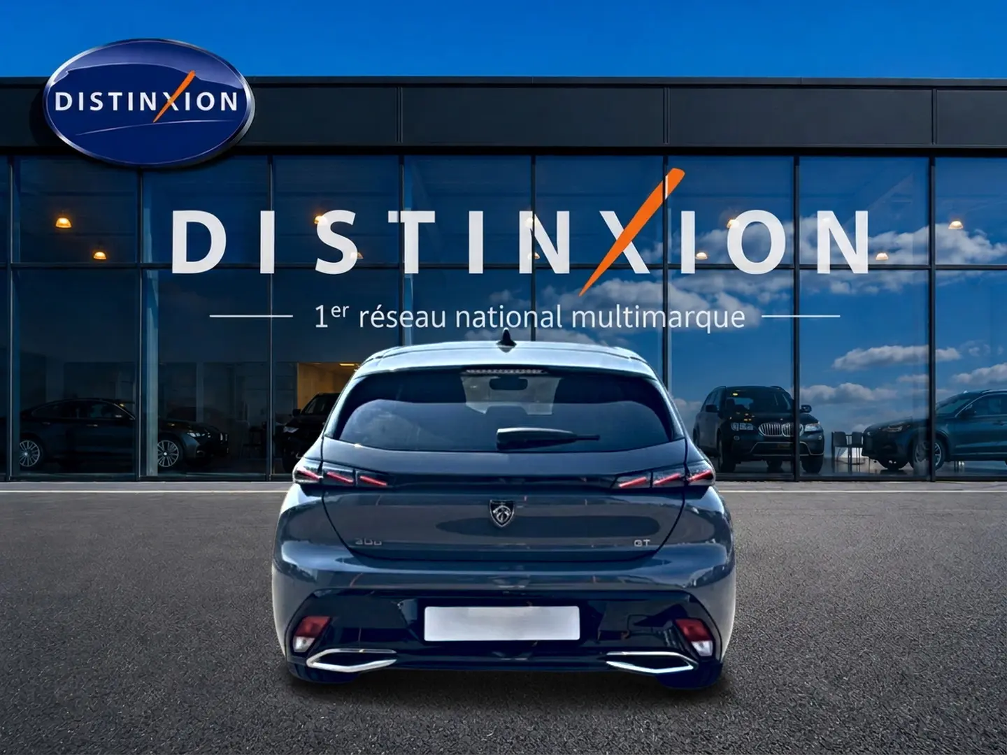 Vue arrière d'une Peugeot 308 gris métallisé 2025 avec feux arrière LED et double sortie d'échappement chromée.