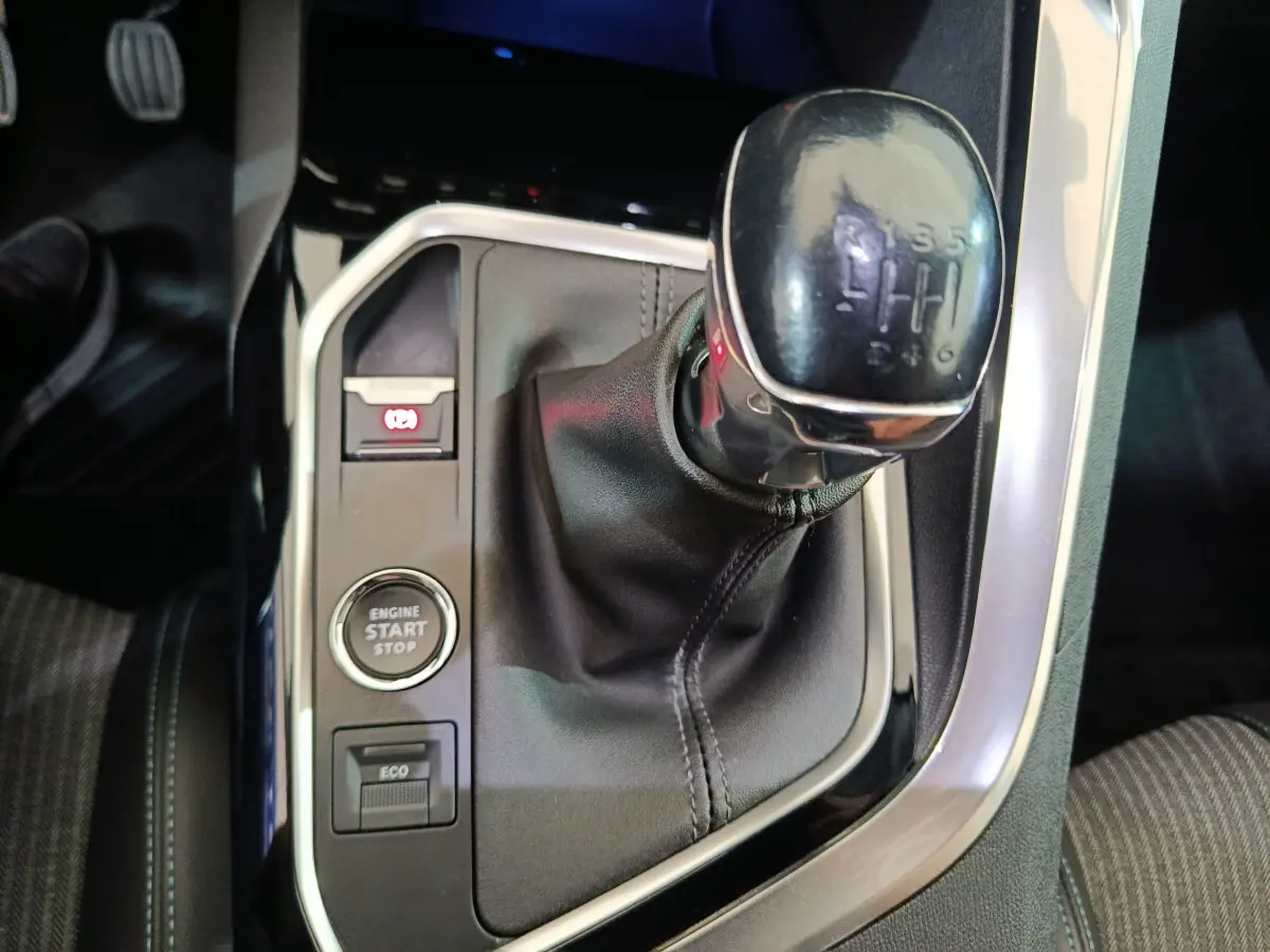 Gros plan sur la commande de boîte manuelle noire et le bouton start/stop dans l'habitacle du Peugeot 3008 bleu.