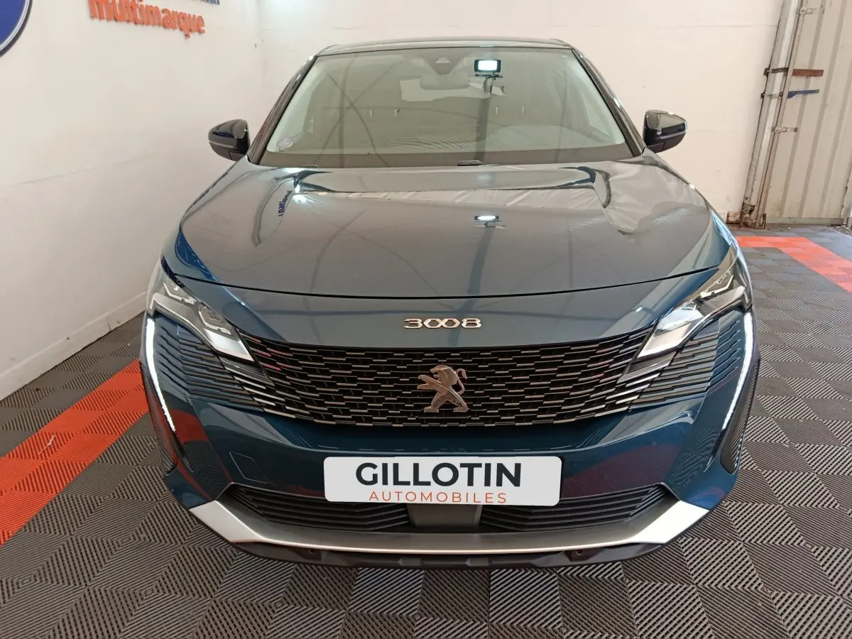 Vue frontale du Peugeot 3008 bleu 2022 avec calandre noire et phares LED distinctifs allumés.