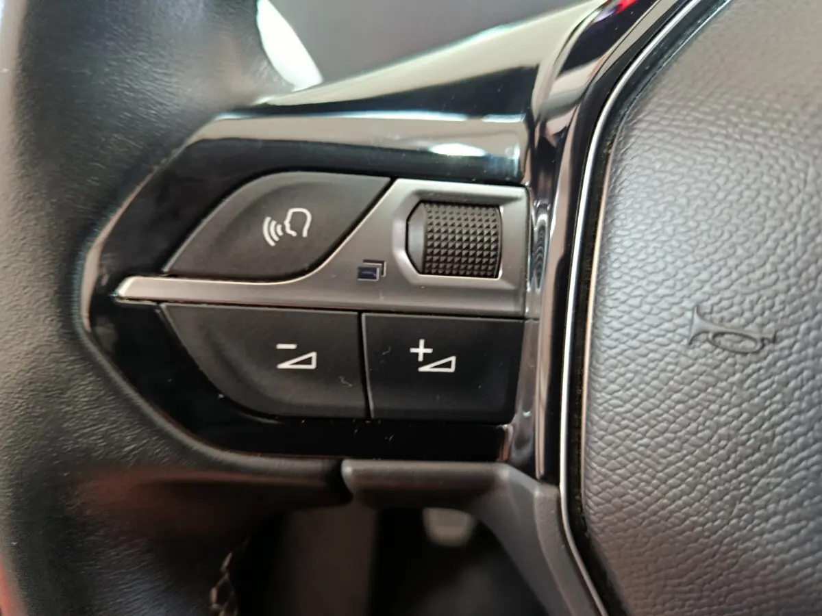 Gros plan sur les commandes gauche du volant cuir du Peugeot 3008 bleu PureTech 130 S&S Allure 2022.