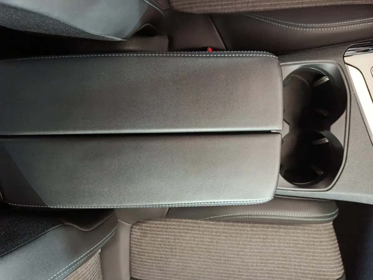 Gros plan sur l'accoudoir central noir et porte-gobelets du Peugeot 3008 PureTech 130 S&S Allure 2022.