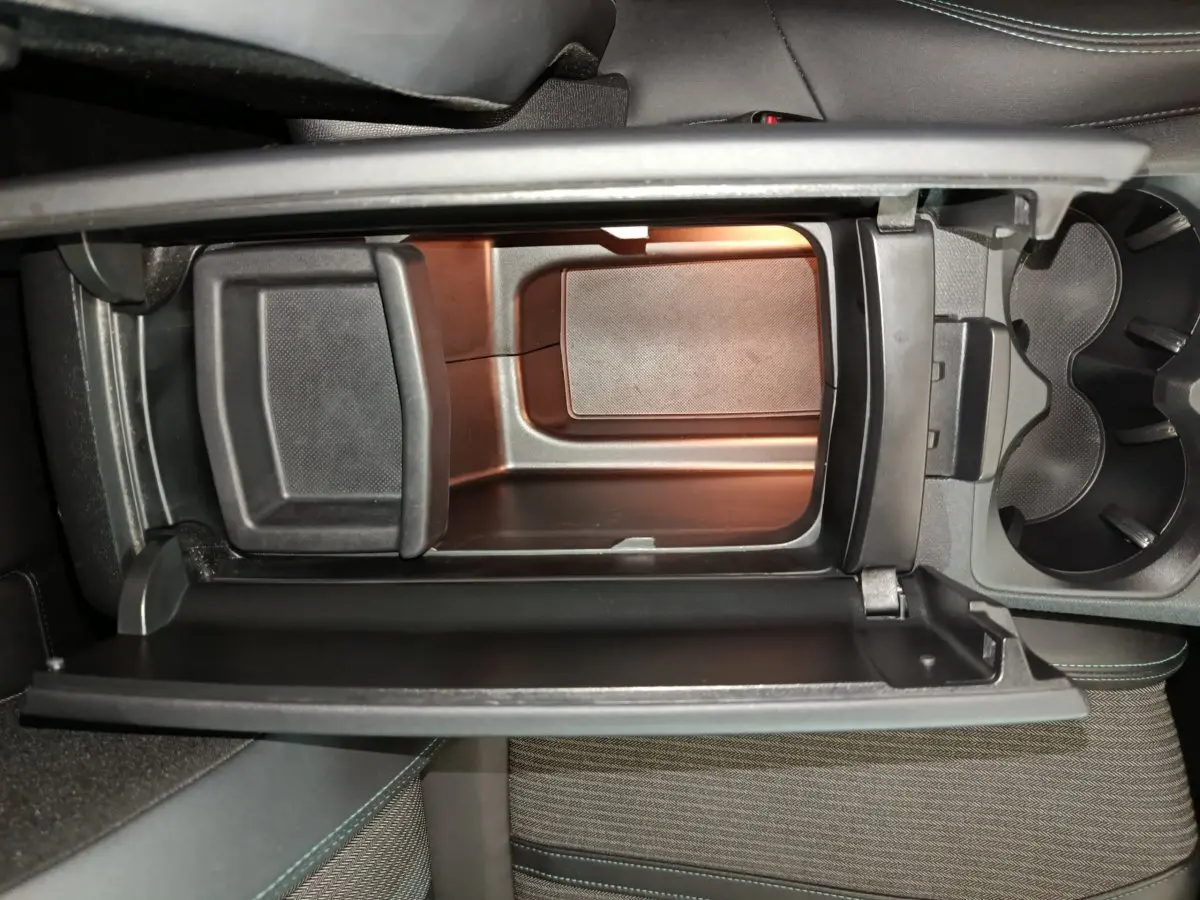 Intérieur du Peugeot 3008 PureTech 130 S&S Allure 2022, vue plongeante sur la console centrale avec rangement ouvert.