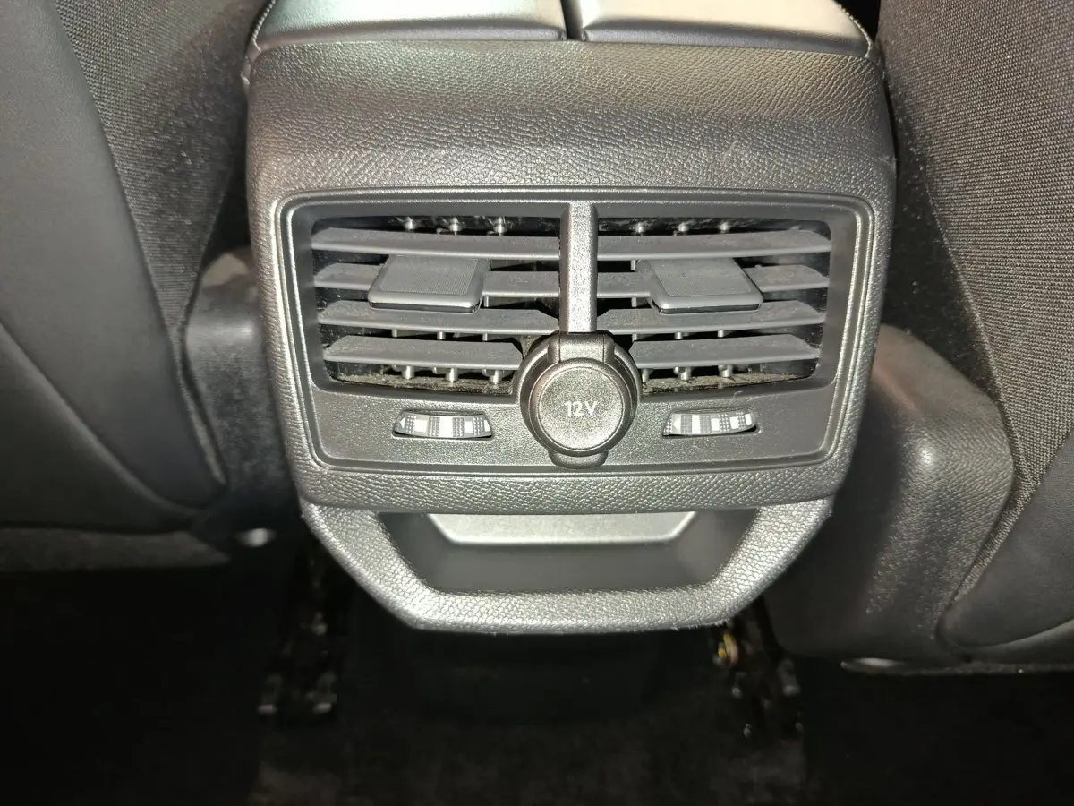 Gros plan sur les bouches d'aération arrière et prise 12V du Peugeot 3008 bleu, intérieur noir.