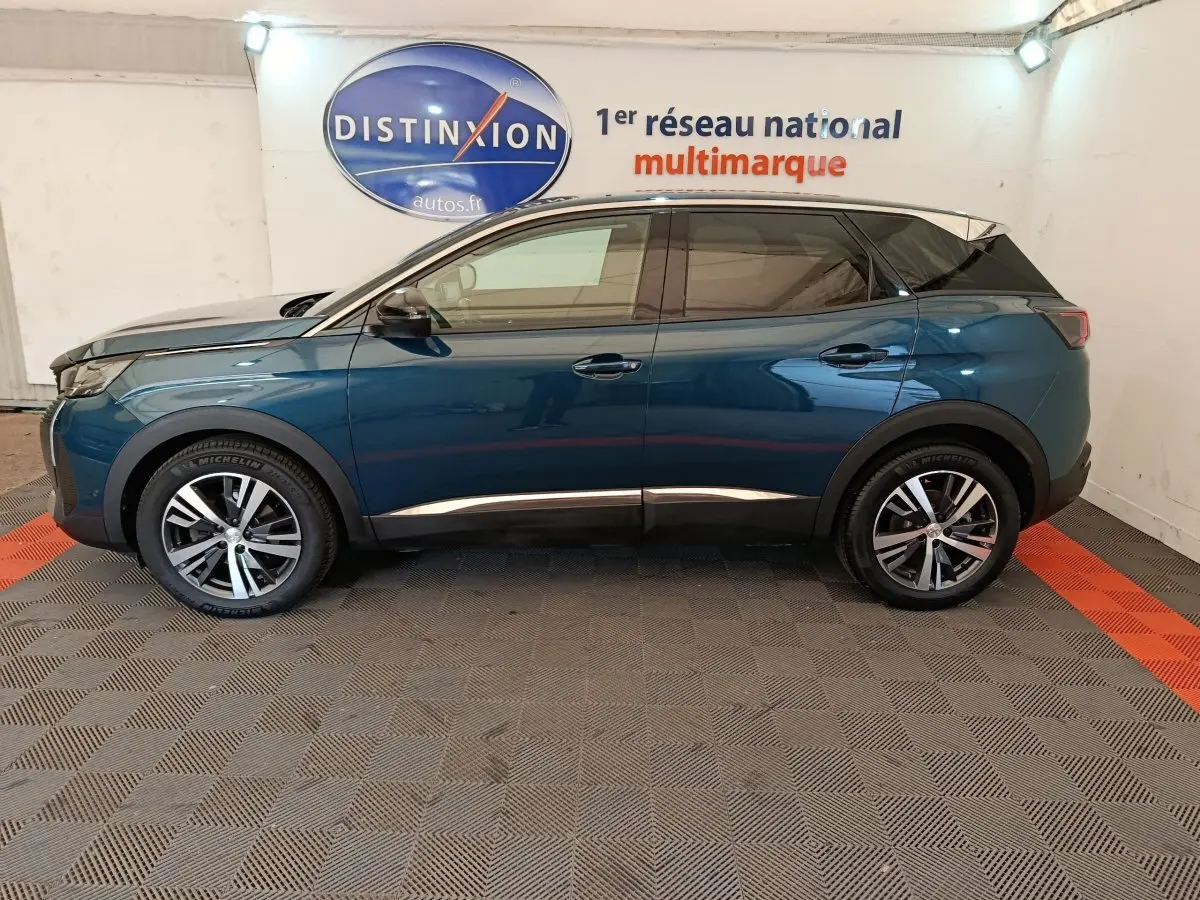Profil côté gauche d'un Peugeot 3008 bleu 2022 avec toit noir, jantes alliage et poignées de porte intégrées.