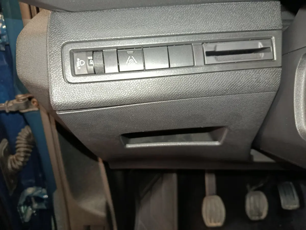 Gros plan sur les commandes sous le tableau de bord côté gauche d'un Peugeot 3008 bleu 2022.