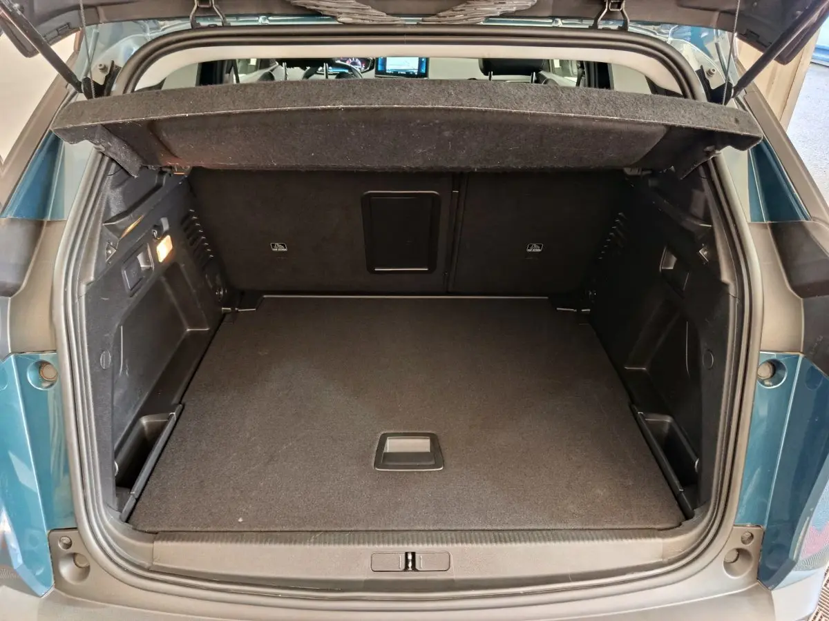Coffre ouvert vu de l'arrière d'un Peugeot 3008 bleu 2022, espace de chargement propre et bien agencé.