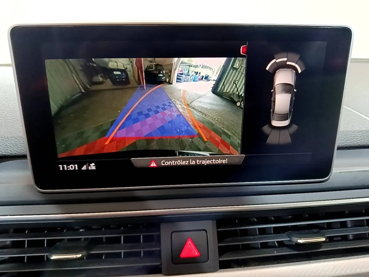 Écran central de l'Audi A4 noir 2018 montrant la caméra de recul et l'alerte de trajectoire en intérieur.