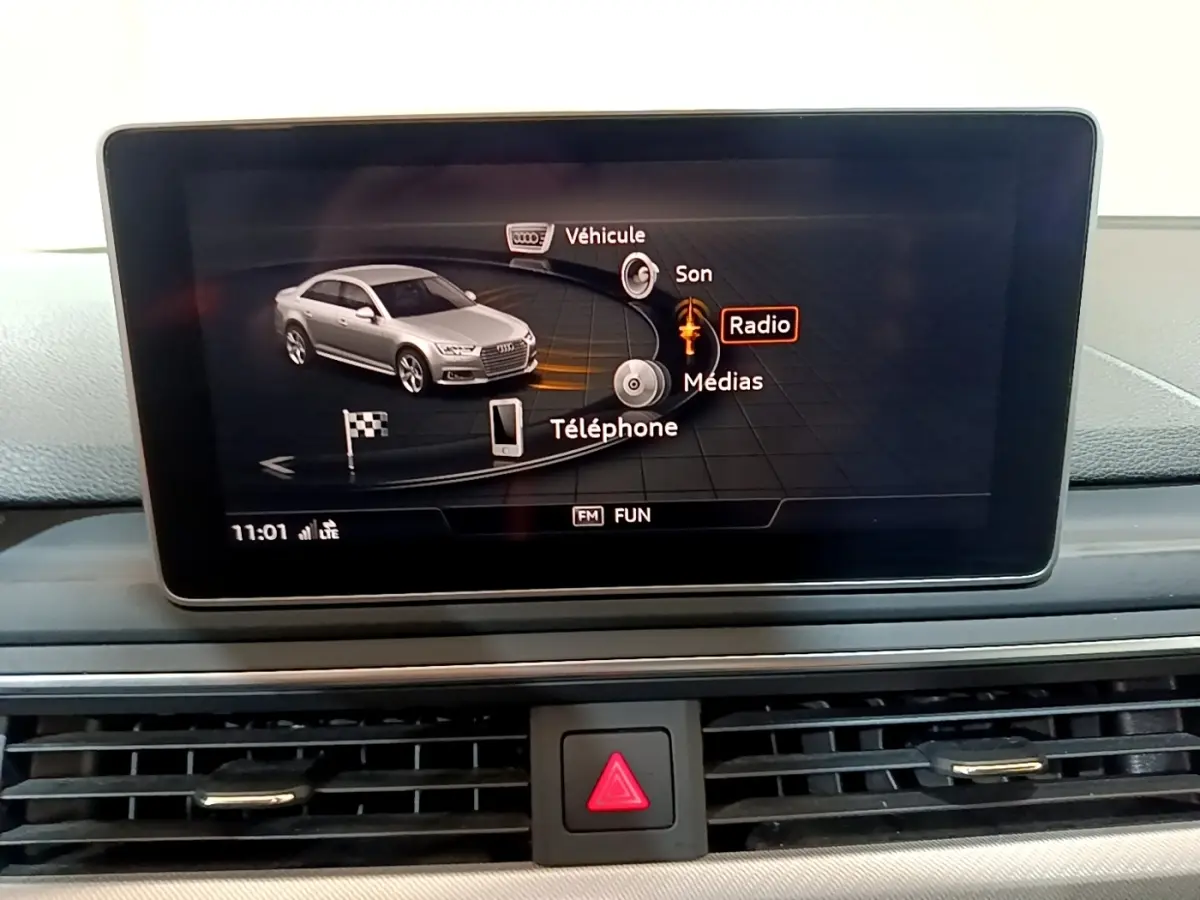 Écran tactile central affichant le menu multimédia avec une Audi A4 grise en illustration, vue intérieure.