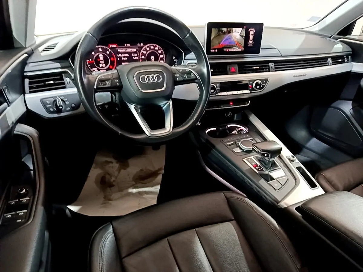 Vue intérieure de l'Audi A4 40 TDI 2018, tableau de bord et console centrale avec écran tactile et volant cuir noir.