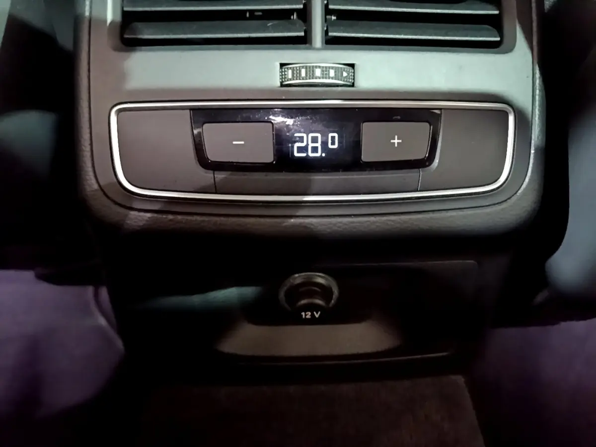 Gros plan sur la commande de climatisation arrière affichant 28°C et prise 12V dans l'Audi A4 noire 2018 Design Luxe.
