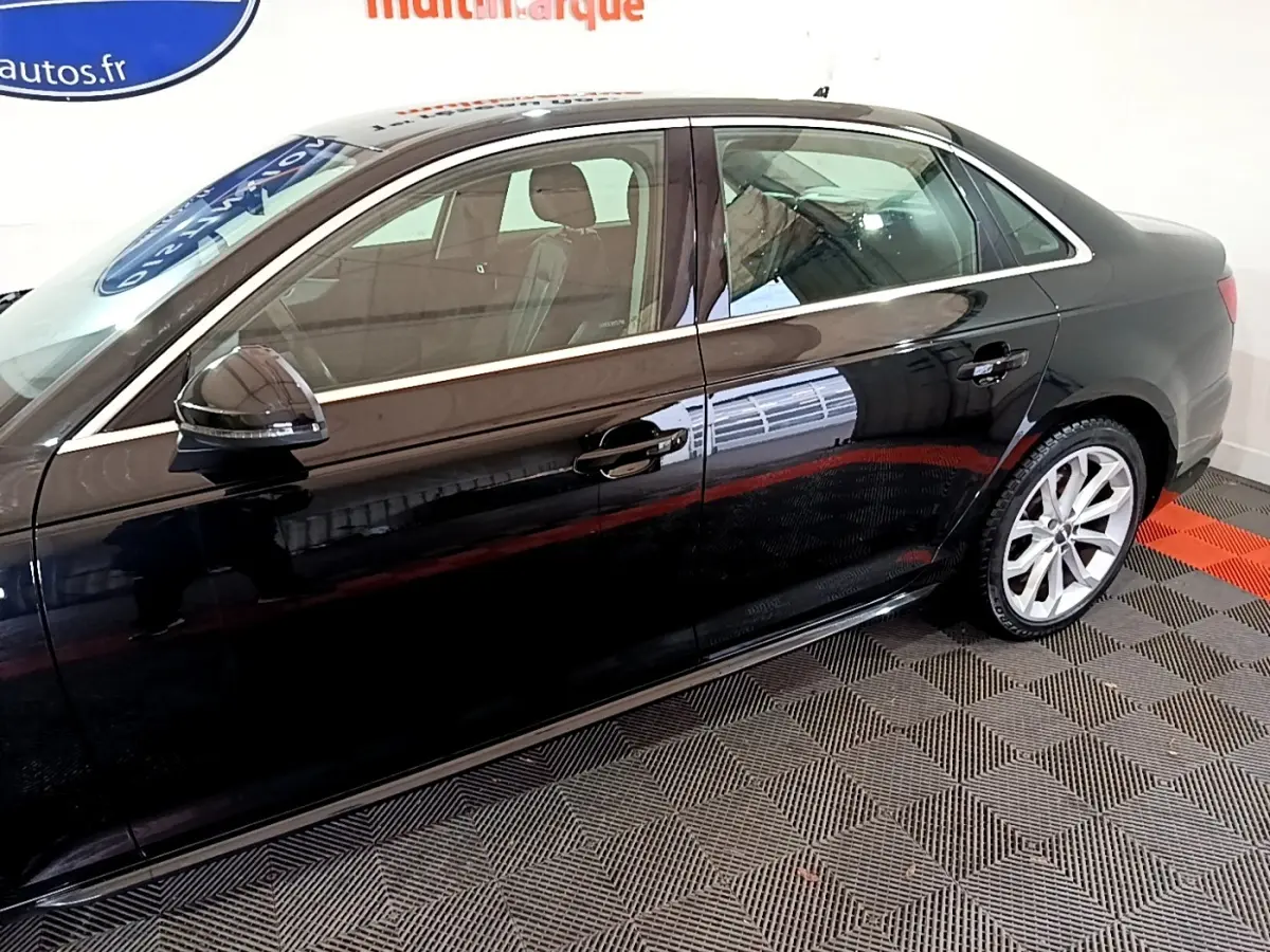 Profil côté gauche d'une Audi A4 noire 2018 avec jantes alliage et rétroviseurs noirs brillants.