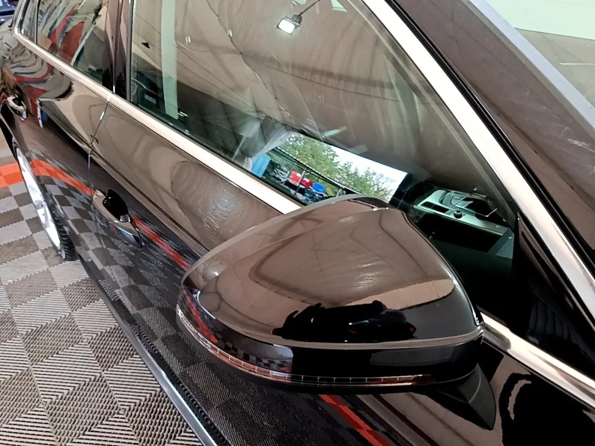 Rétroviseur noir brillant côté gauche d'une Audi A4 40 TDI 190 Quat S tronic Design Luxe 2018 avec carrosserie noire.