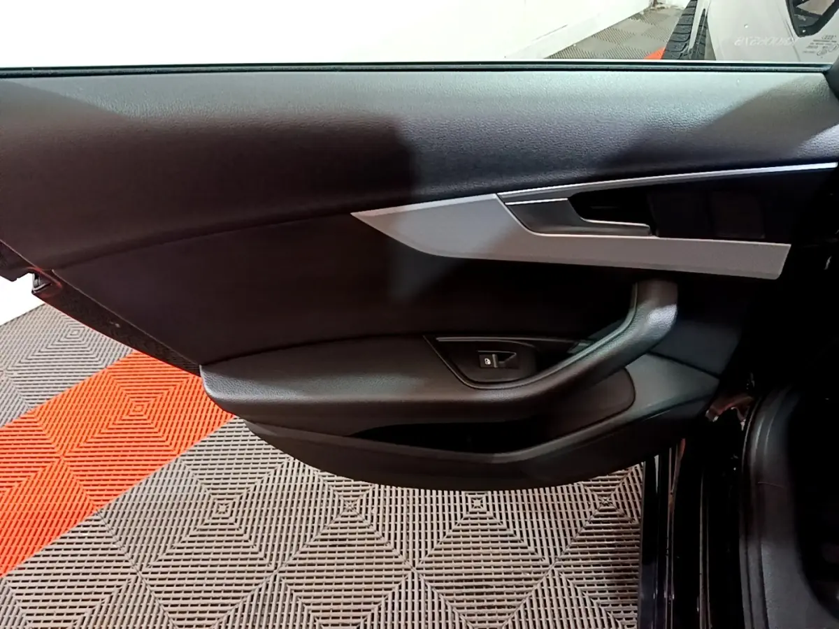 Vue rapprochée de la porte côté gauche noire de l'Audi A4 40 TDI 2018 avec insert argenté et commande de vitre électrique.