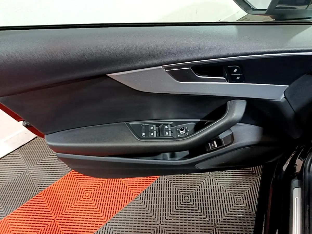 Vue rapprochée de la porte avant gauche noire d'une Audi A4 40 TDI 190 Quat S tronic Design Luxe avec commandes électriques.