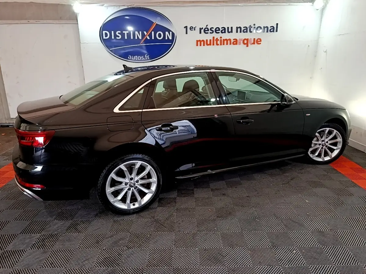 Audi A4 noire vue de profil côté gauche dans un showroom avec jantes alliage et vitres teintées.