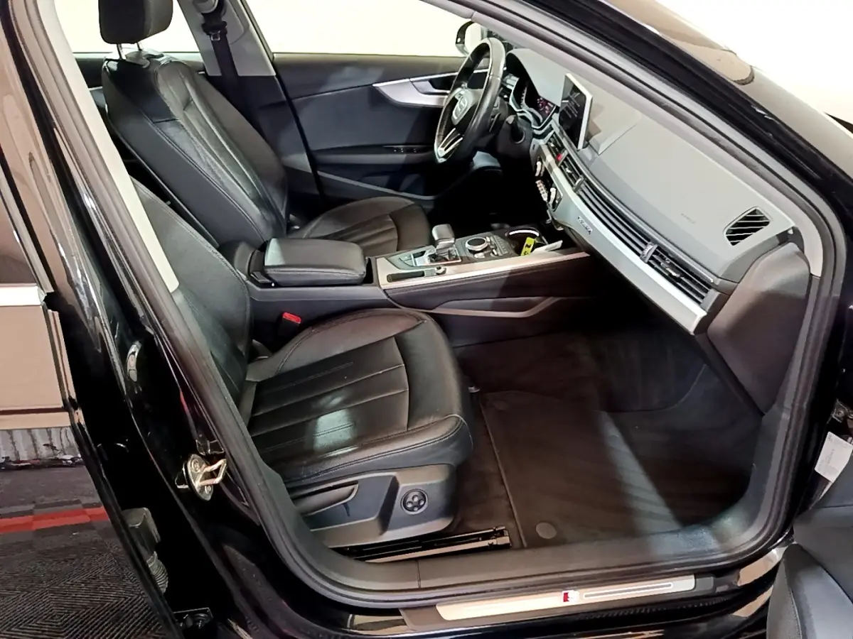 Intérieur noir de l'Audi A4 40 TDI 2018 vu côté conducteur, avec sièges cuir et tableau de bord moderne.