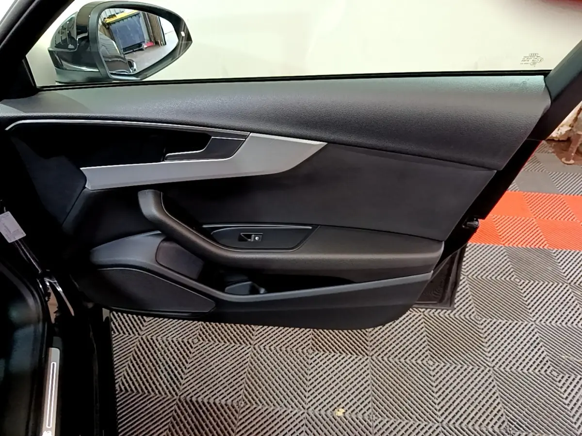 Vue rapprochée de la porte côté gauche noire de l'Audi A4 40 TDI 2018 avec garniture grise et poignée intégrée.