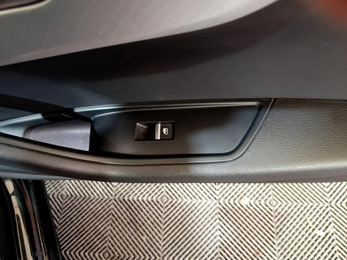 Bouton de commande de lève-vitre sur la porte intérieure noire de l'Audi A4 40 TDI 2018, côté gauche.