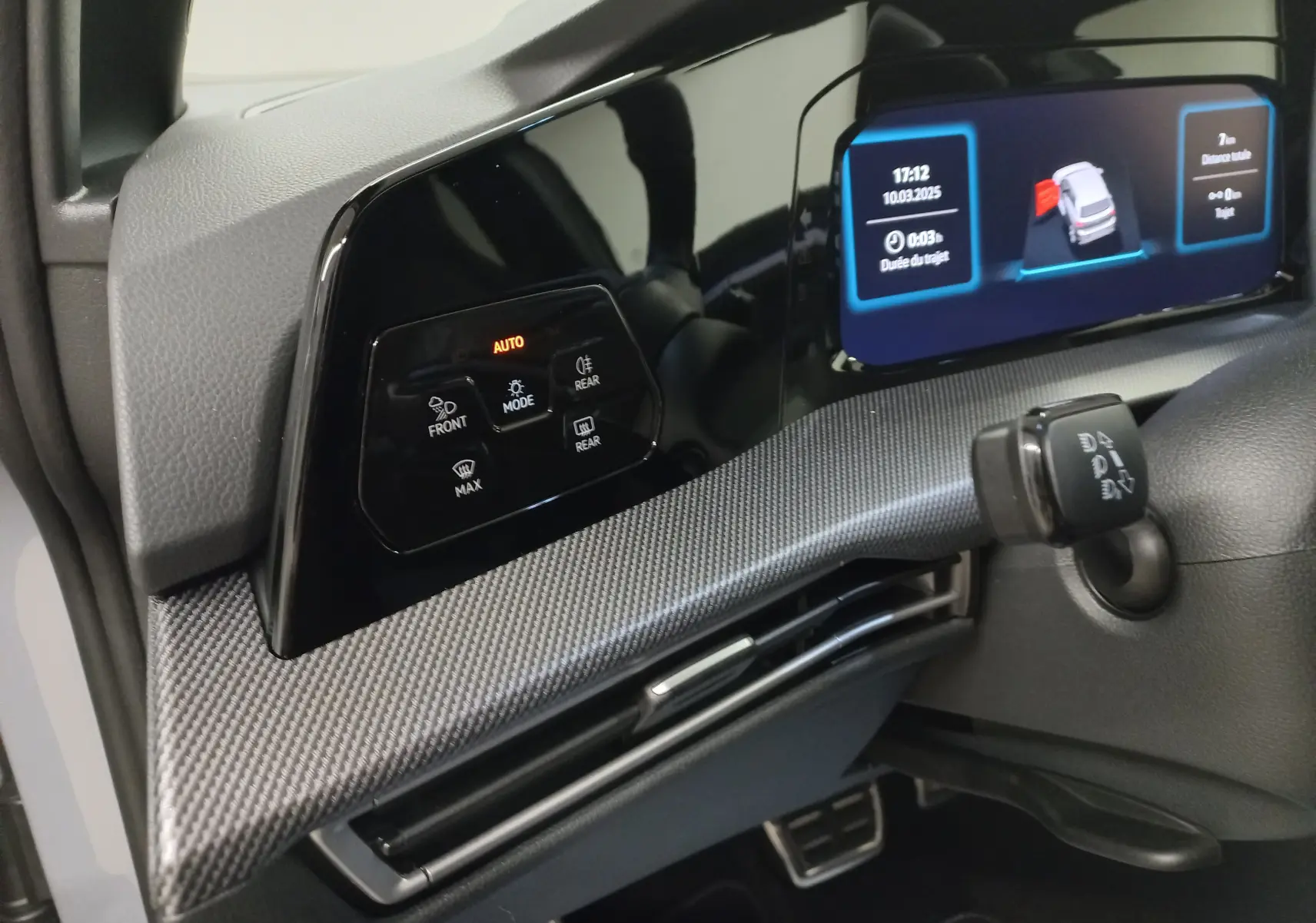 Vue rapprochée du tableau de bord de la Volkswagen Golf 2.0 TDI gris lunaire, mettant en valeur l'écran digital et les commandes tactiles.