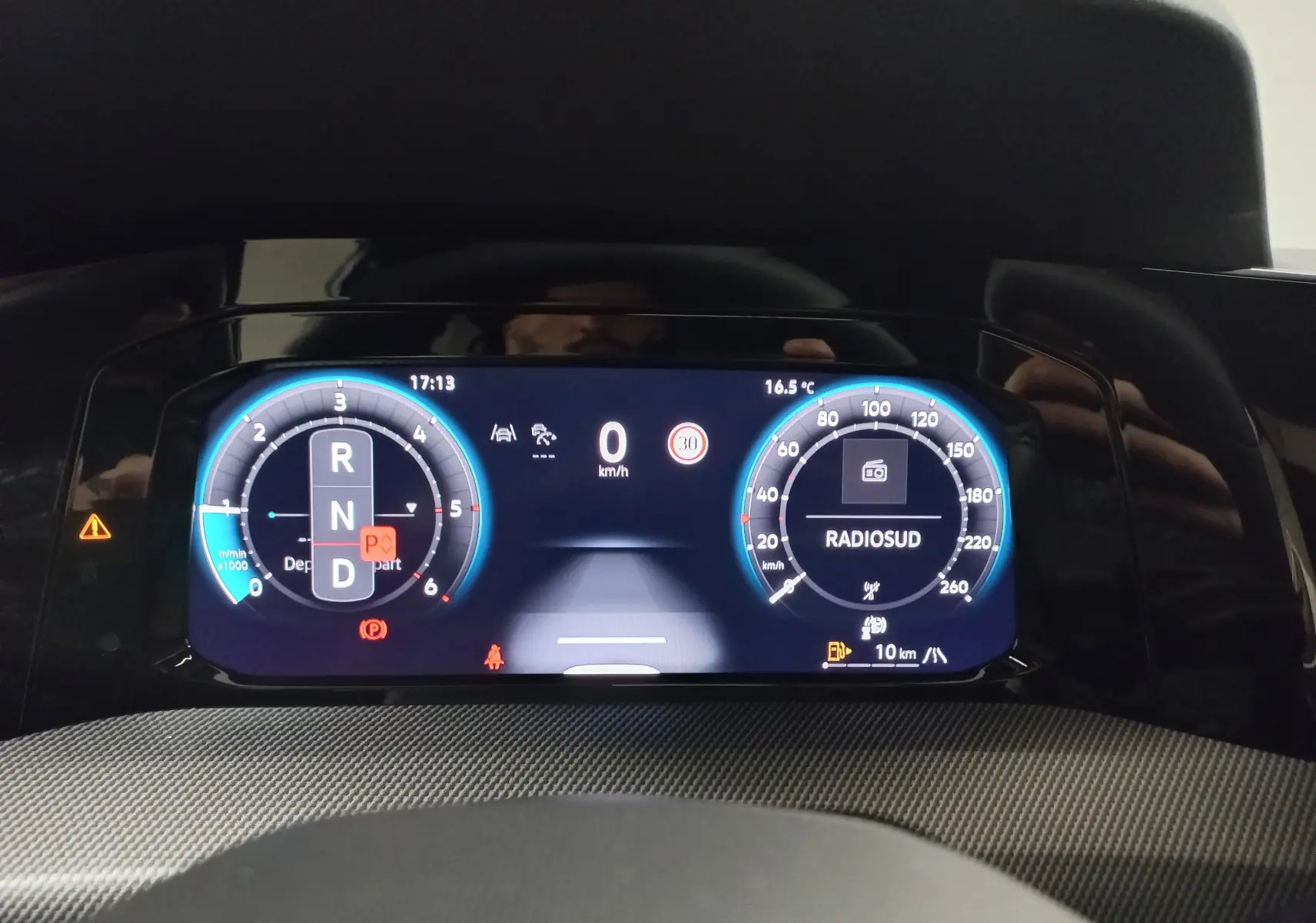 Vue rapprochée du tableau de bord numérique de la Volkswagen Golf 2.0 TDI 150 DSG7 R-Line, affichage vitesse et radio.