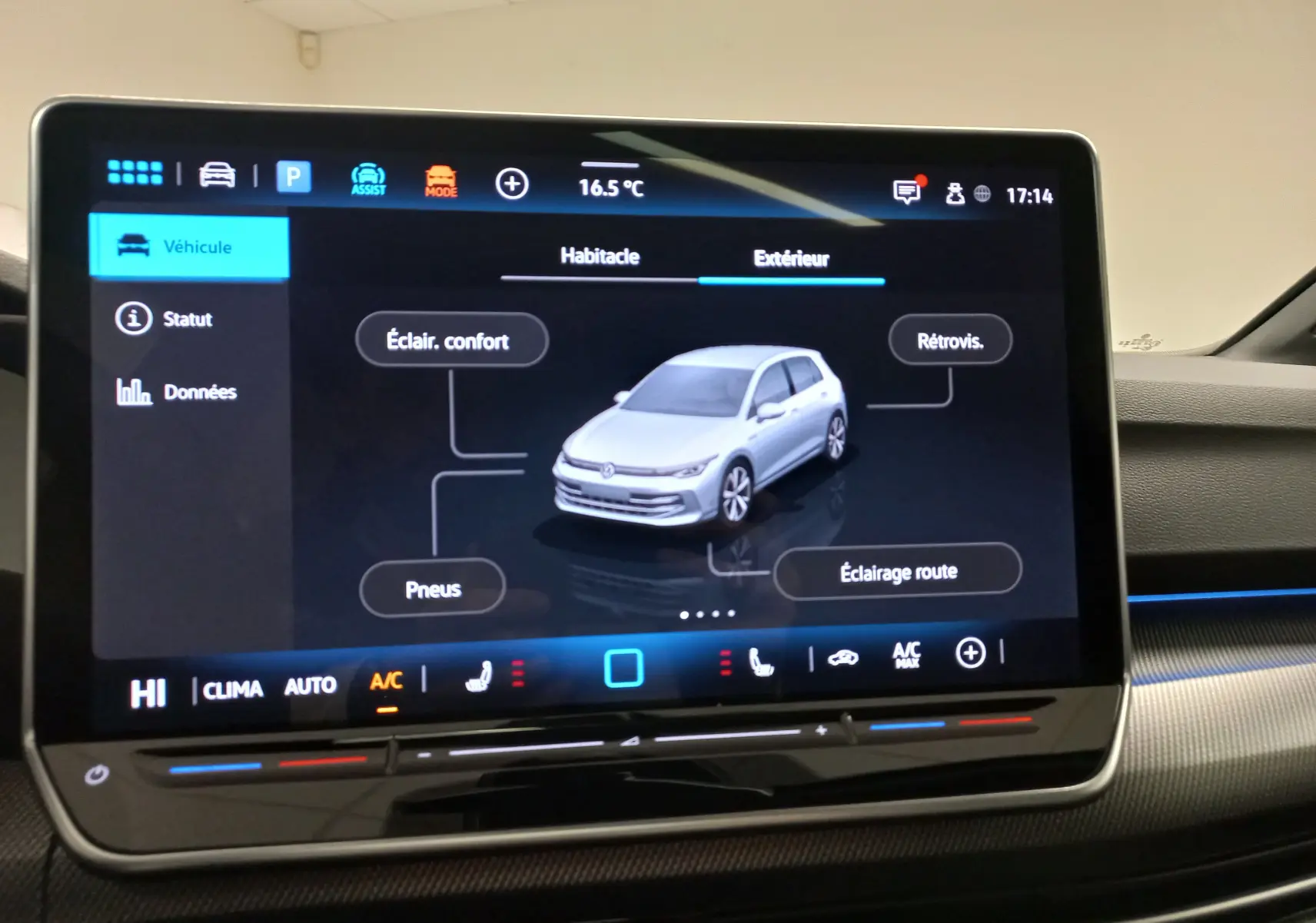 Écran tactile intérieur affichant la vue 3D d’une Volkswagen Golf gris lunaire avec options d’éclairage et pneus.