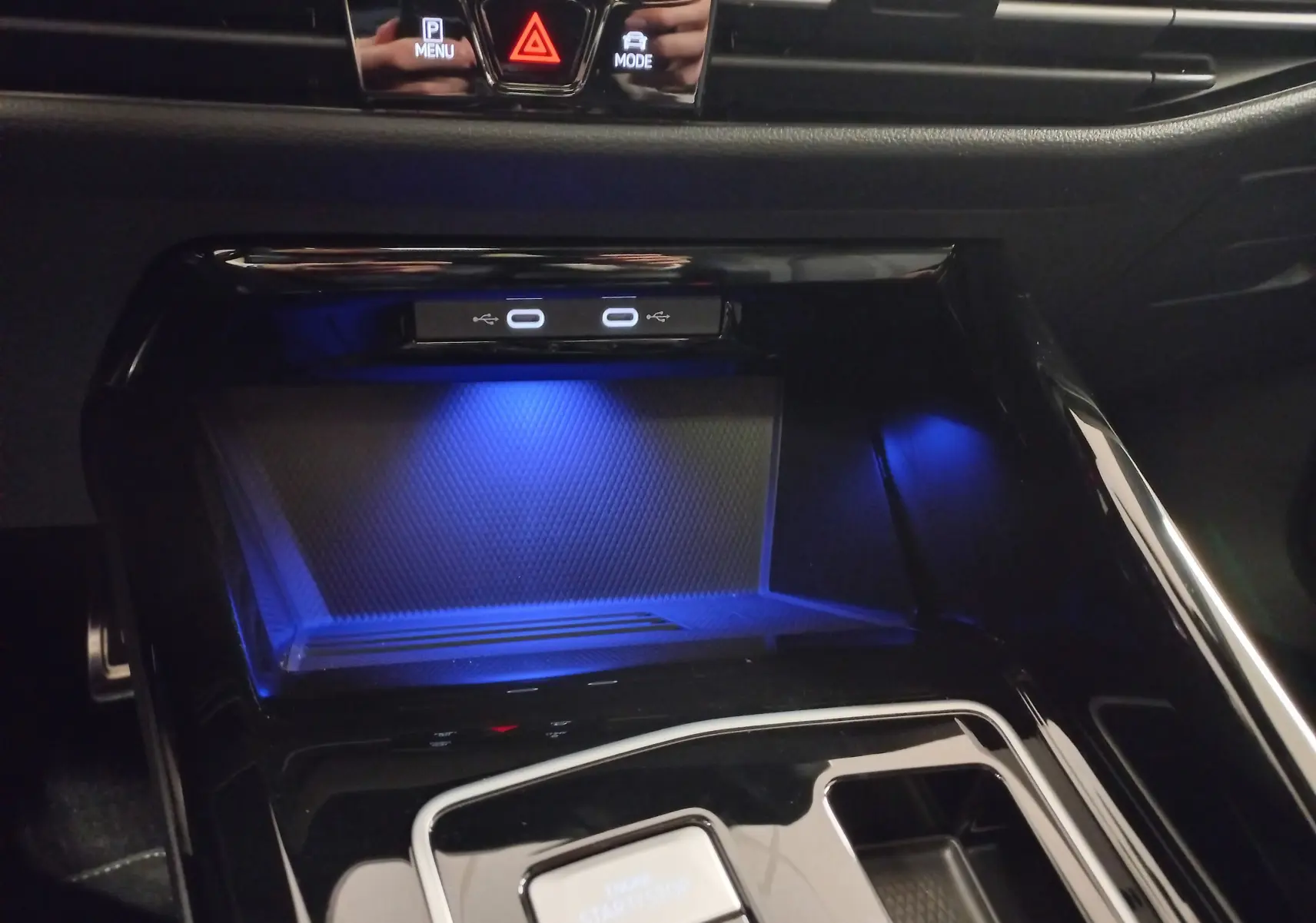 Gros plan intérieur sur la console centrale de la Volkswagen Golf 2.0 TDI R-Line 2026 avec éclairage bleu et ports USB.