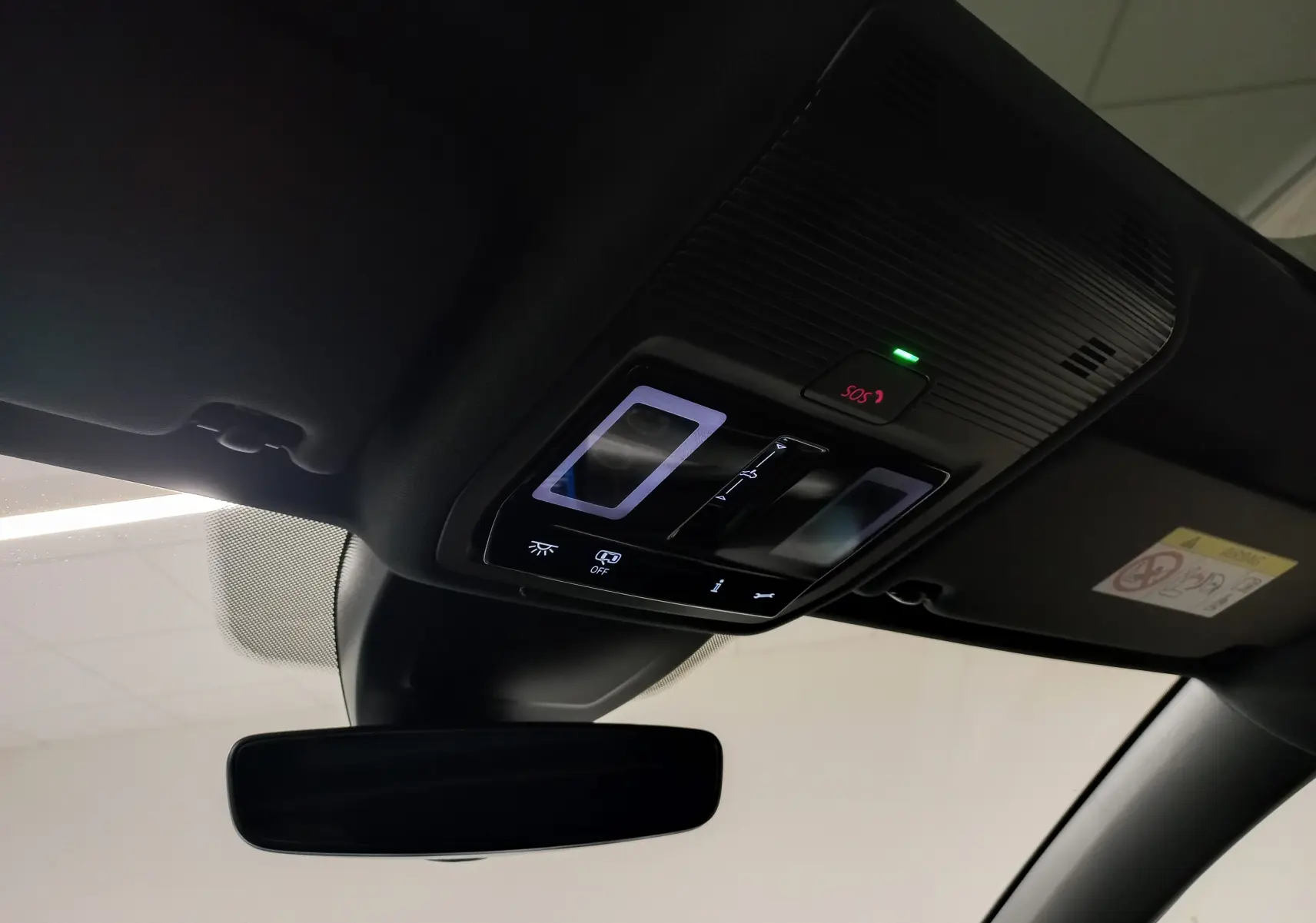 Vue intérieure du toit ouvrant panoramique avec commandes lumineuses et bouton SOS de la Volkswagen Golf gris lunaire 2026.