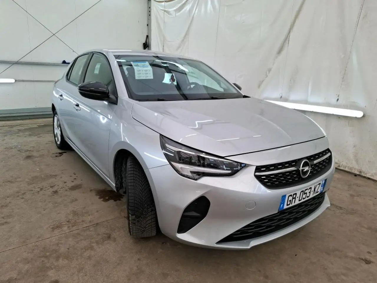 Vue 3/4 avant droite d'une Opel Corsa gris clair avec calandre noire et jantes alliage 16 pouces.