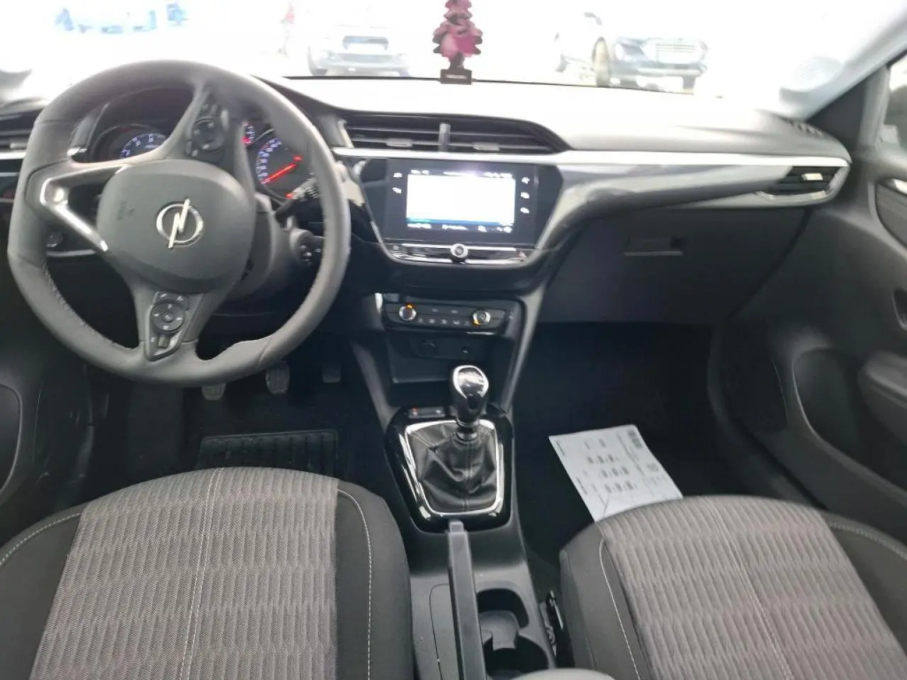 Vue intérieure avant de l’Opel Corsa 2023, tableau de bord noir avec écran tactile et levier de vitesses manuel.