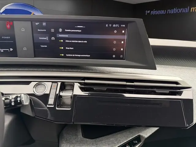 Tableau de bord du Peugeot 5008 Allure Hybrid blanc, vue centrée sur l'écran tactile et la console noire laquée.