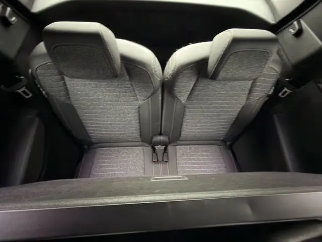Vue plongeante sur les sièges arrière en tissu gris et noir du Peugeot 5008 Nouveau Allure Hybrid 145 blanc Okenite.