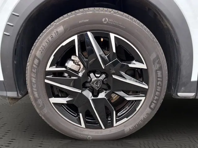Gros plan sur la jante alliage noire et argentée du côté gauche d’un Peugeot 5008 blanc Okenite, pneu Michelin visible.