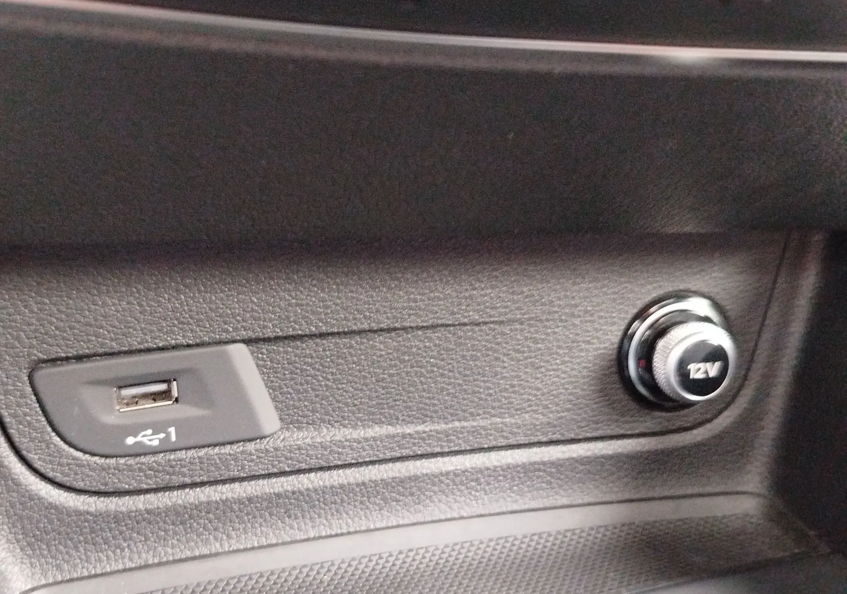 Gros plan sur la prise USB et l’allume-cigare 12V dans l’habitacle noir de l’Audi Q2 35 TFSI S line 2023.