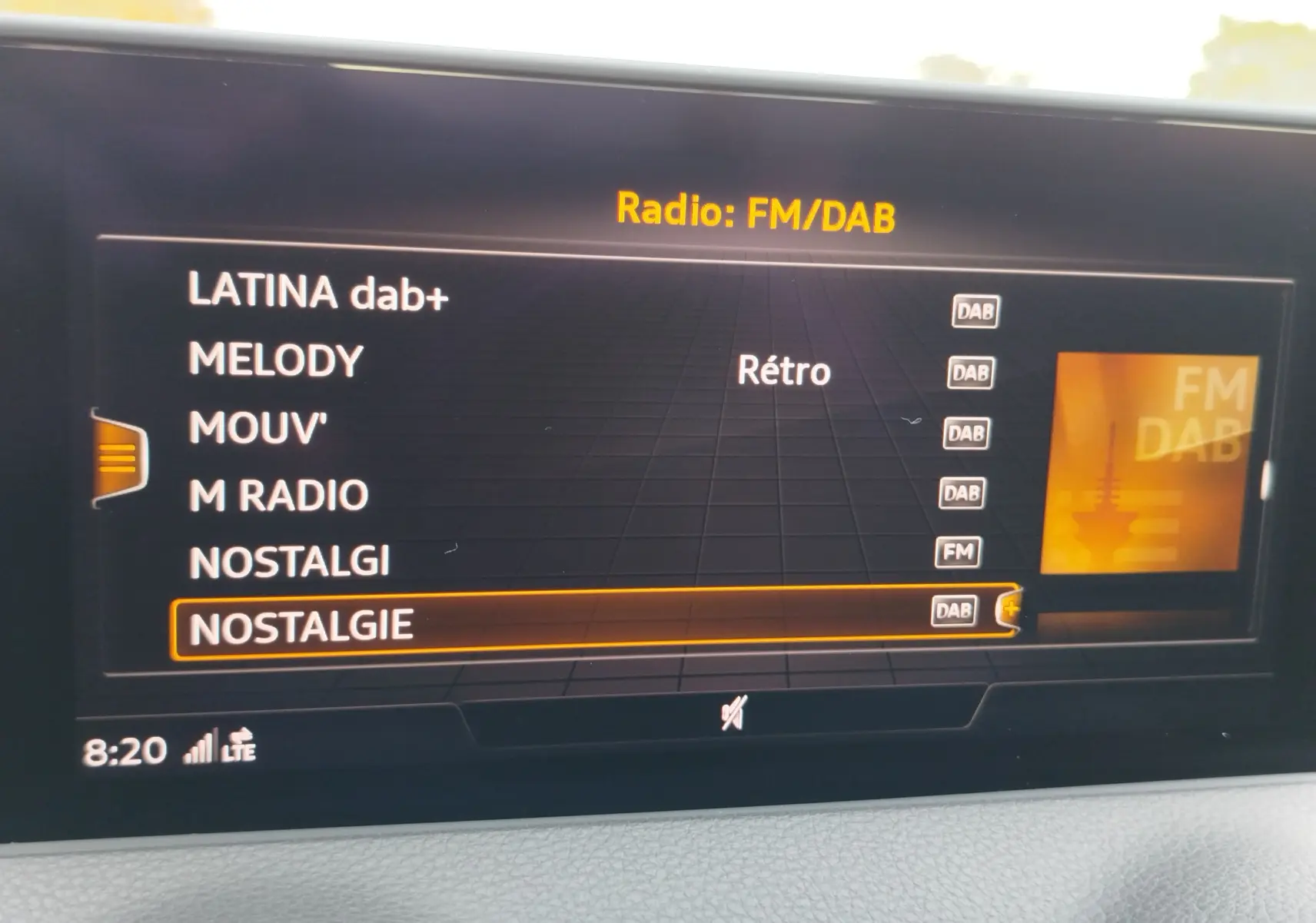 Écran multimédia de l'Audi Q2 35 TFSI 2023 affichant la liste des radios DAB/FM en intérieur gris.