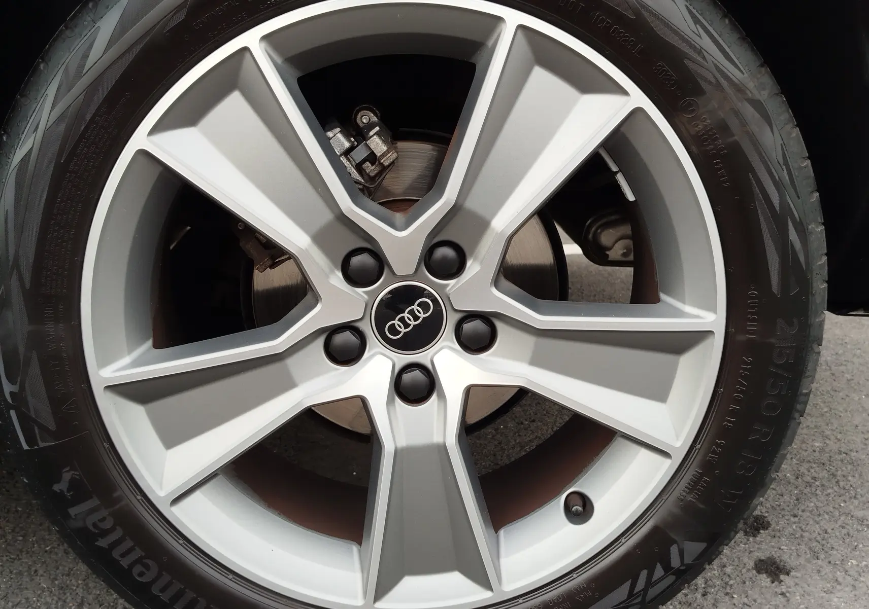 Gros plan sur la jante en alliage argentée avec logo Audi au centre, montée sur pneu Continental.