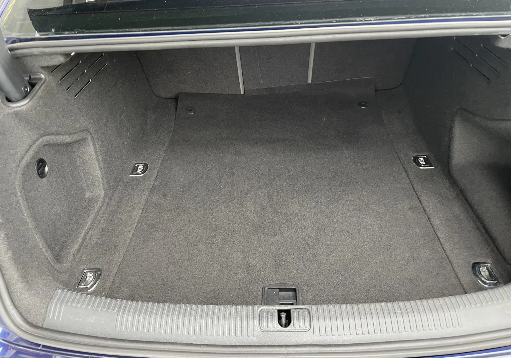 Coffre ouvert de l'Audi S4 bleu Navarre de 2016, montrant un espace de chargement propre et bien fini.