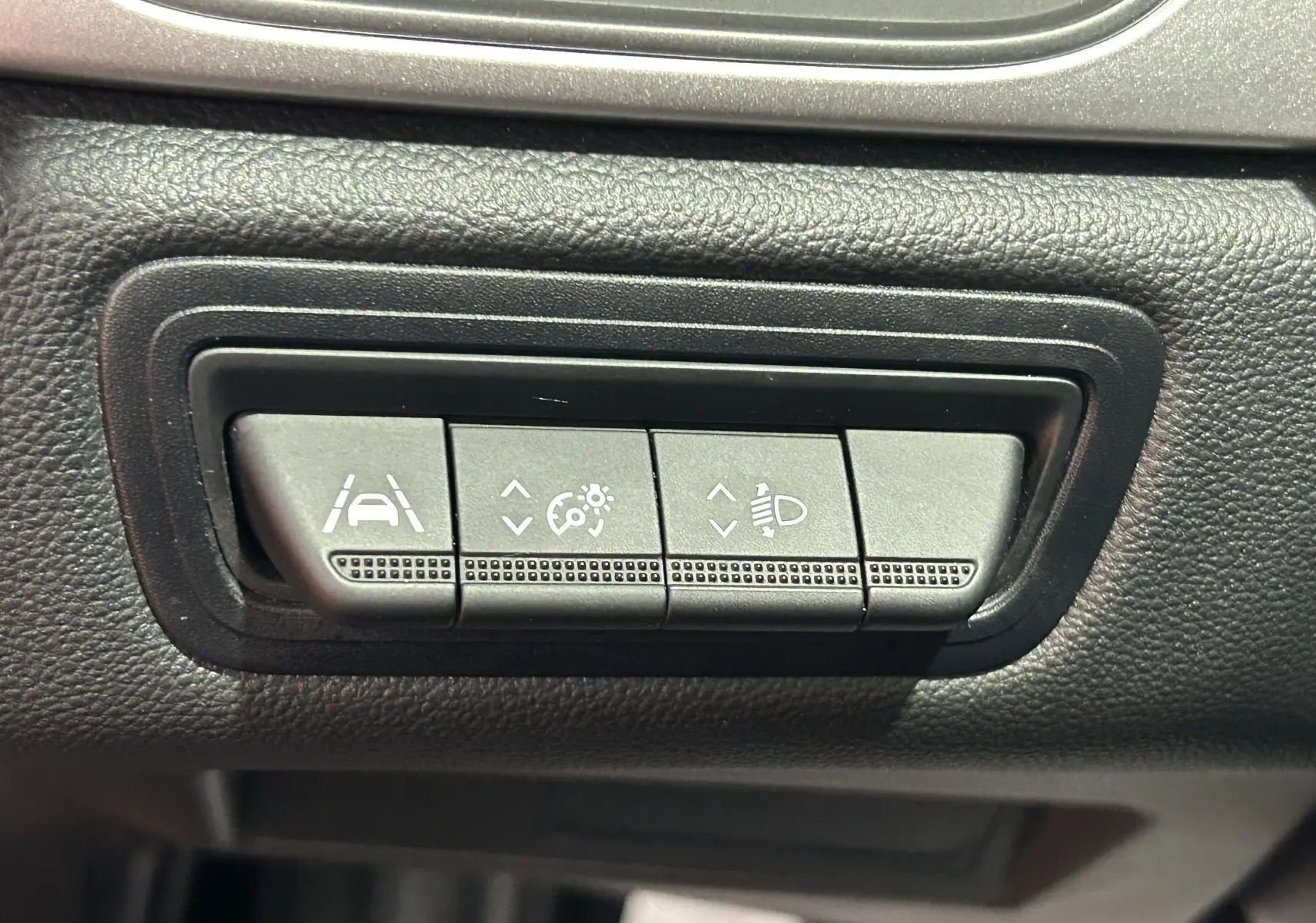 Boutons de réglage d'assistance à la conduite et éclairage sur tableau de bord en plastique noir du Renault Captur rouge flamme 2024.