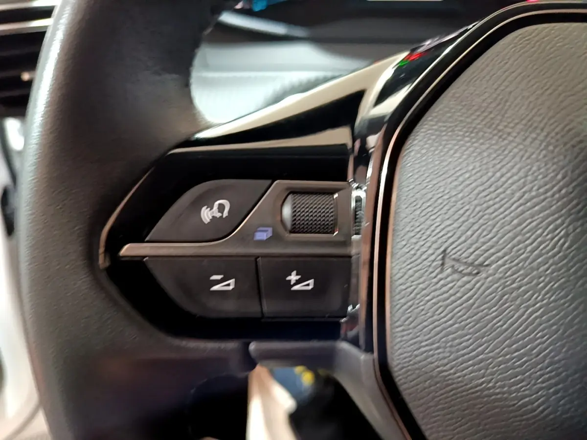 Gros plan sur les commandes gauche du volant cuir du Peugeot 208 Electrique Active Business blanc, 2021.