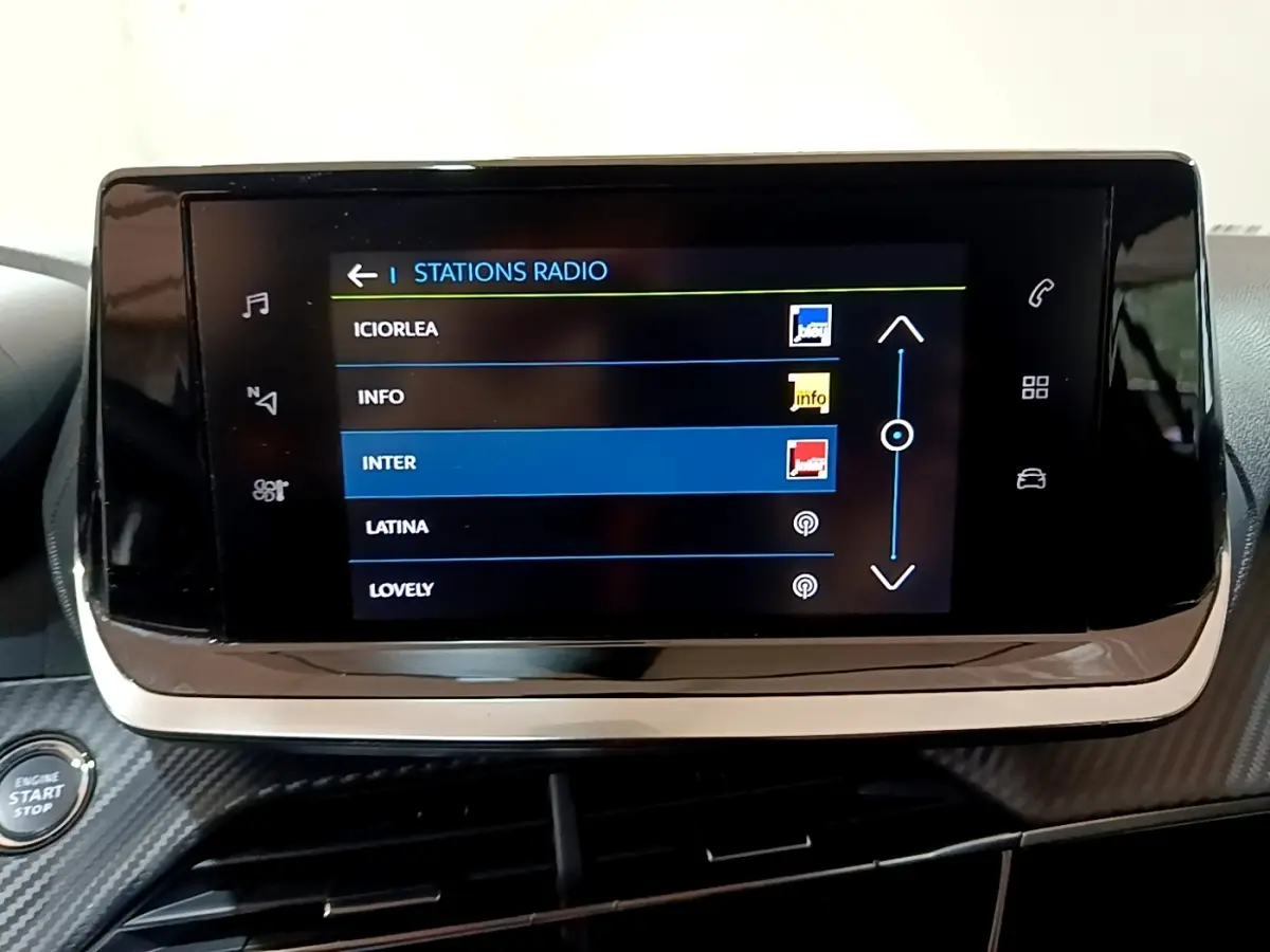 Écran tactile central affichant les stations radio dans l’habitacle d’une Peugeot 208 électrique Active Business blanche.