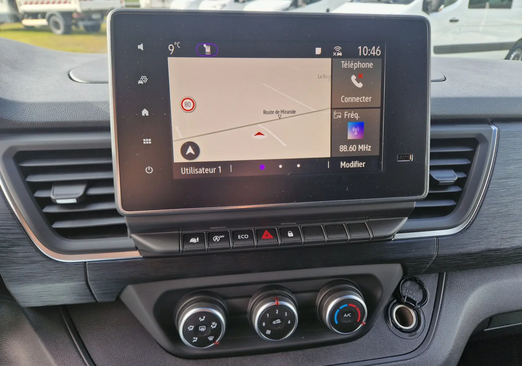 Vue rapprochée de l'écran tactile central et de la console de climatisation du Nissan Primastar blanc 2025, finition N-Connecta.